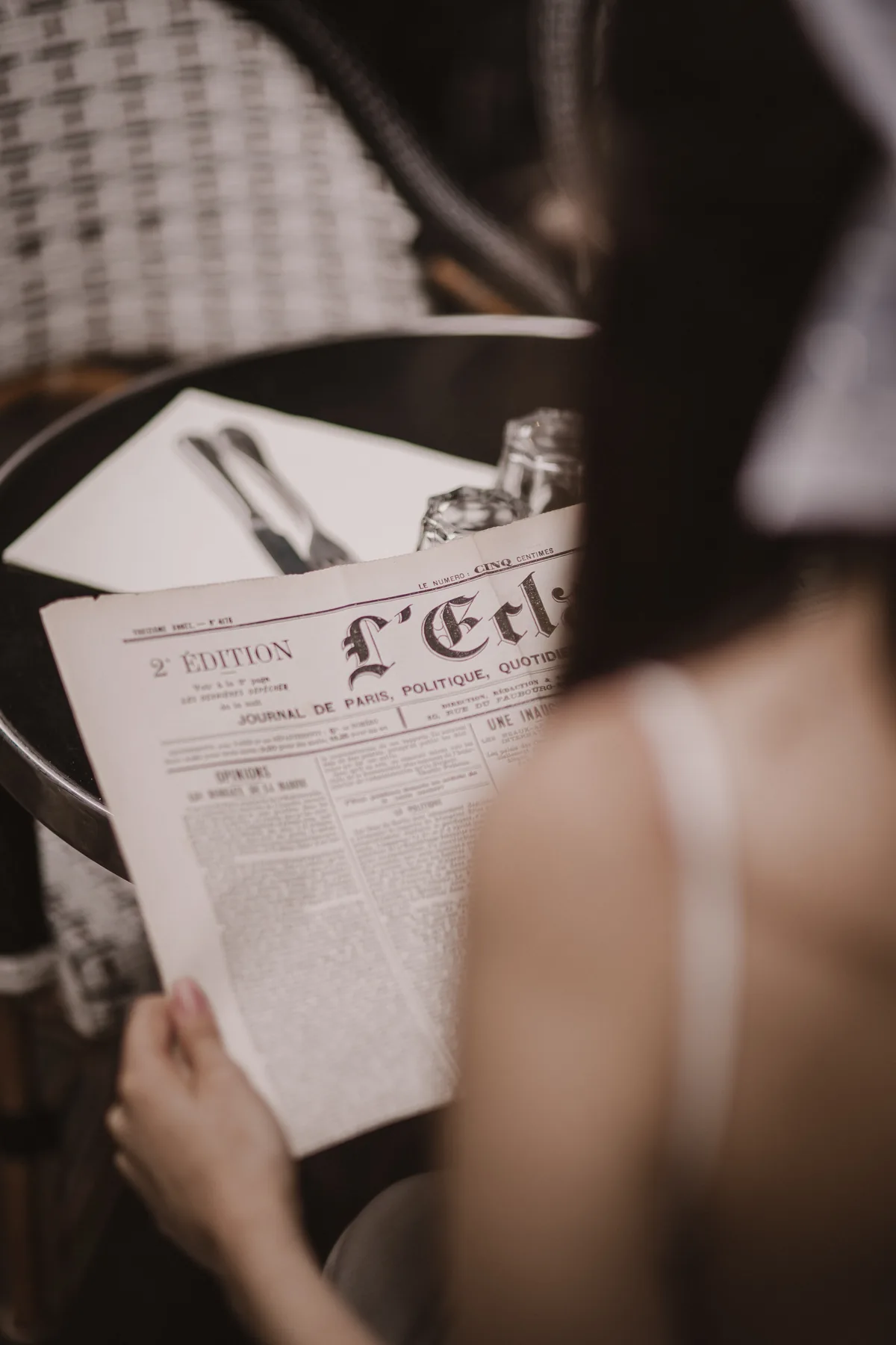 Braut liest eine französische Zeitung im Café